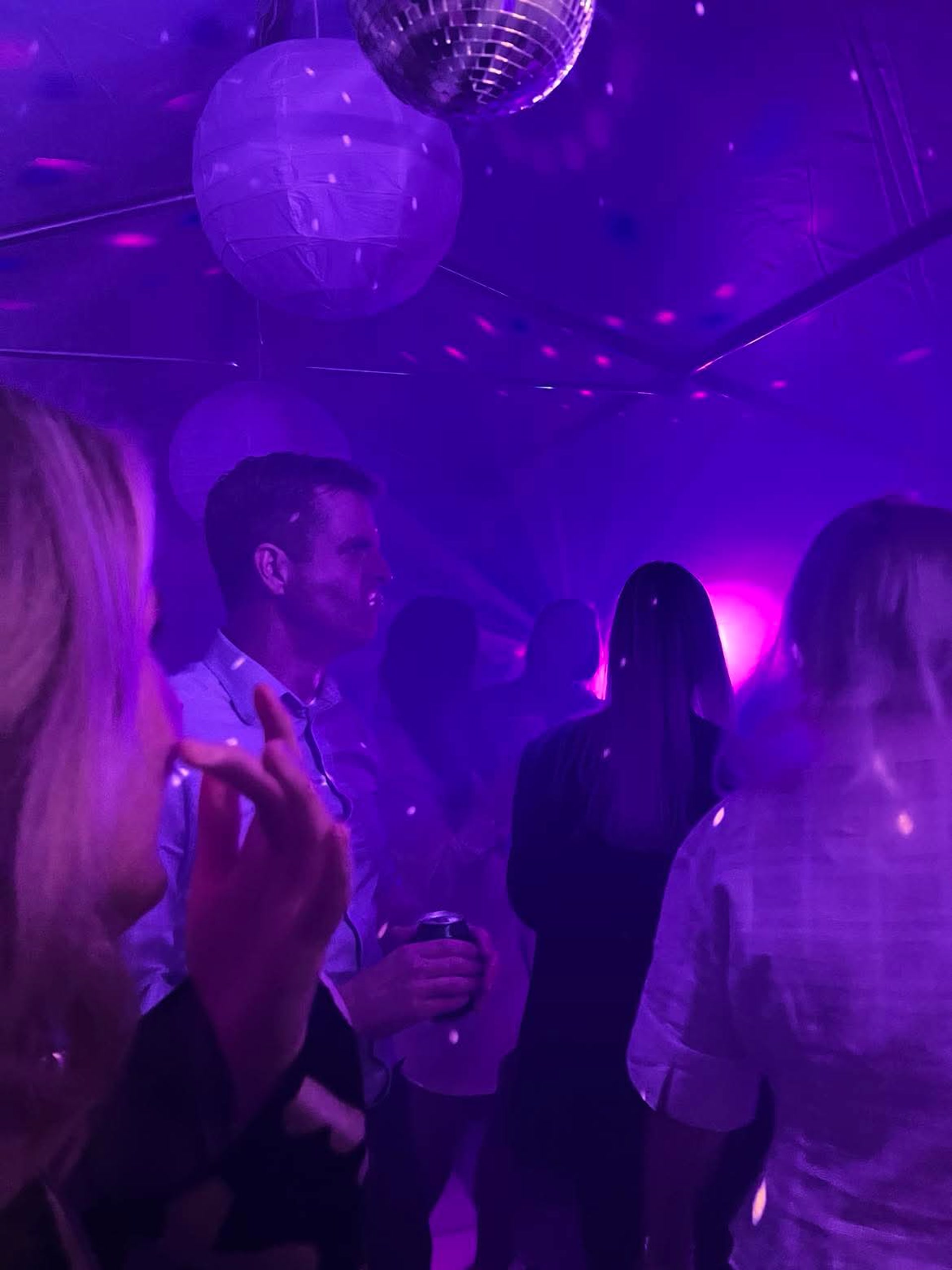 Gäster under lila eventljus på företagsfest