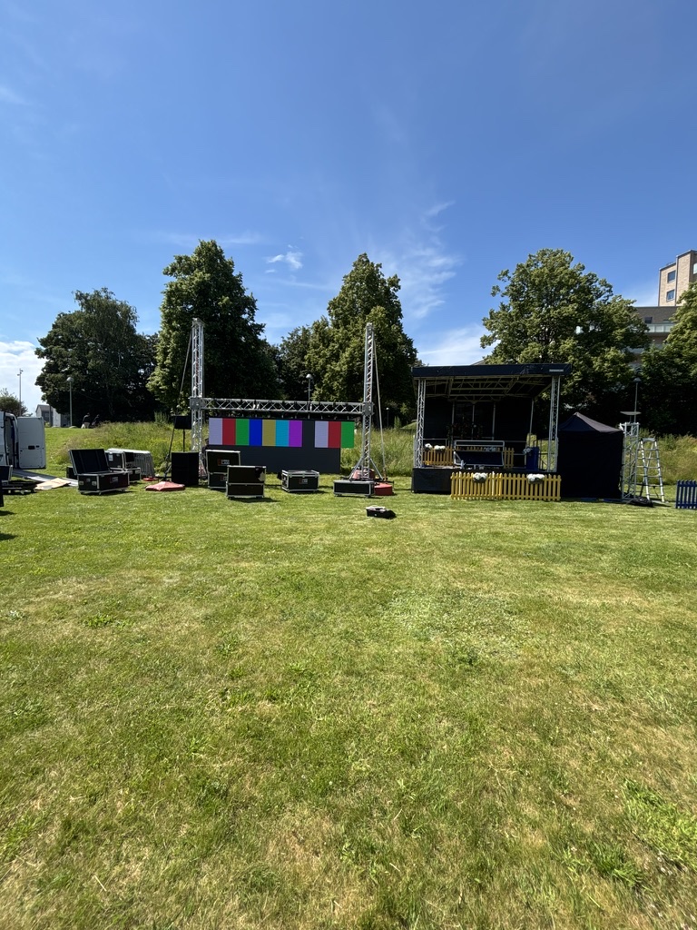 Utomhusrigg med LED-skärm, scen och eventutrustning på gräsmatta